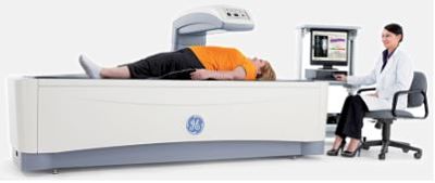 Picture of a female patient lying flat back while having a bone density test in a scanner.